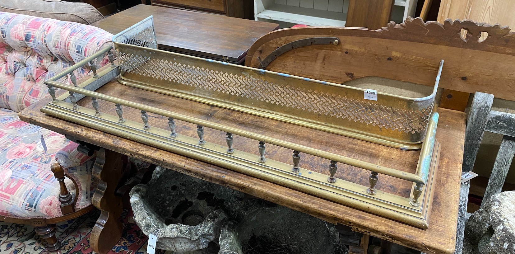 An Edwardian balustraded brass fender, width 134cm and a similar pierced brass fire kerb, width 124cm